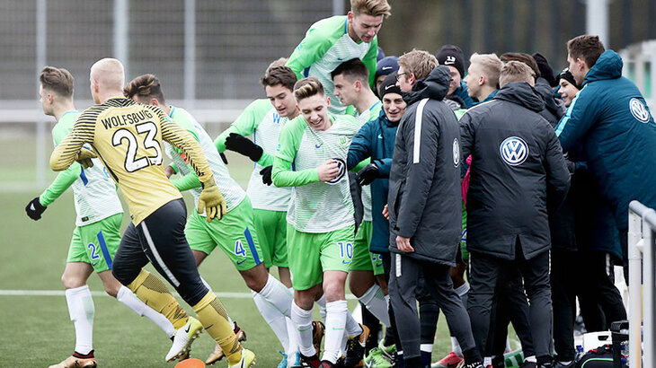 Das Team der U17 vom VfL Wolfsburg jubelt mit dem, Betreuerstab über den Sieg gegen FC St. Pauli. 