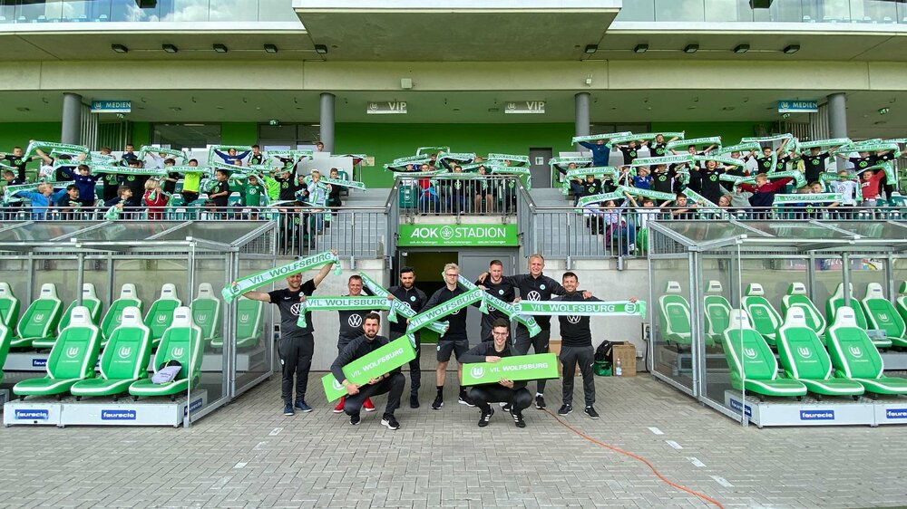 Fans und Mitarbeiter des VfL Wolfsburg auf einem Gruppenfoto im AOK Stadion.