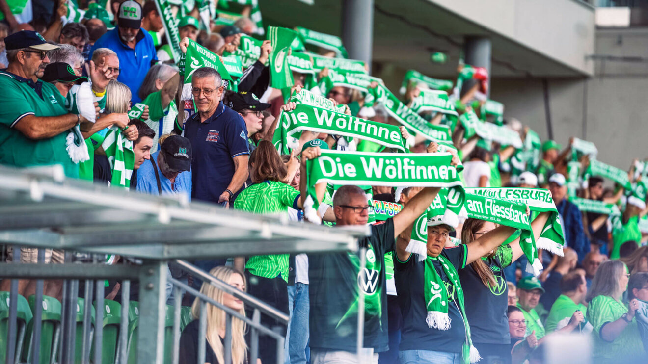 Fans der Frauenmannschaft des VfL Wolfsburg während einem Spiel.