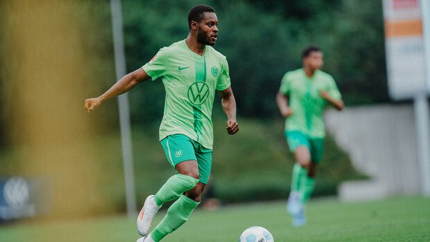 VfL-Wolfsburg-Spieler Ridle Baku läuft mit dem Ball am Fuß über den Rasen.