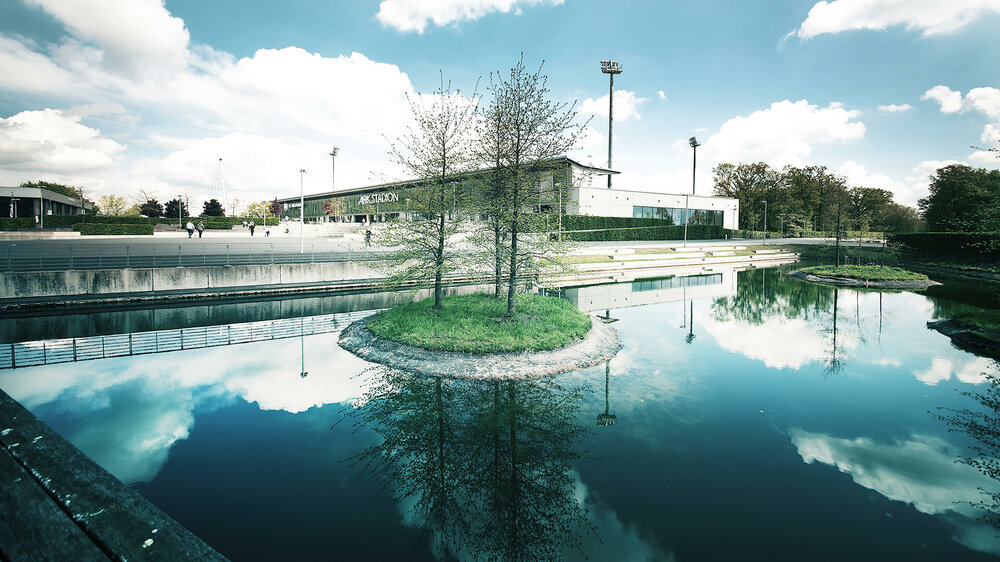 Aussenaufnahme des AOK Stadions - im Vordergrund ein Teich. 