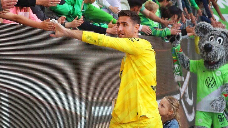 Der VfL-Wolfsburg-Spieler Koen Casteels klatscht mit einem Fan ab.