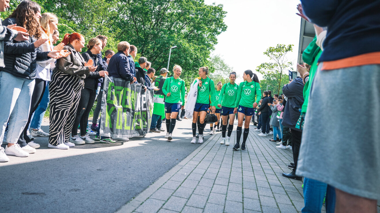 Die Mitarbeiter und Fans des VfL Wolfsburg bilden ein Spalier für die Spielerinnen.
