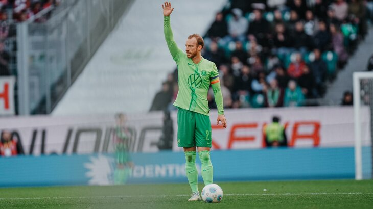 Der VfL-Wolfsburg-Spieler Maximilian Arnold hebt den Arm.