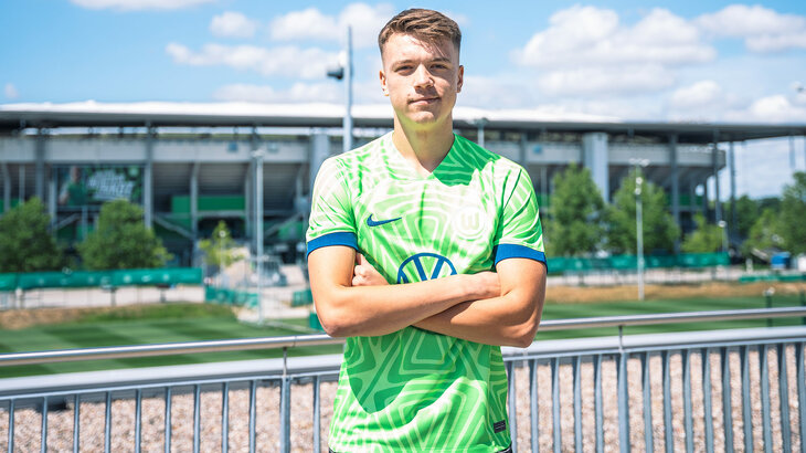 Der VfL Wolfsburg-Spieler Dzenan Pejcinovic und die Volkswagen Arena im Hintergrund.