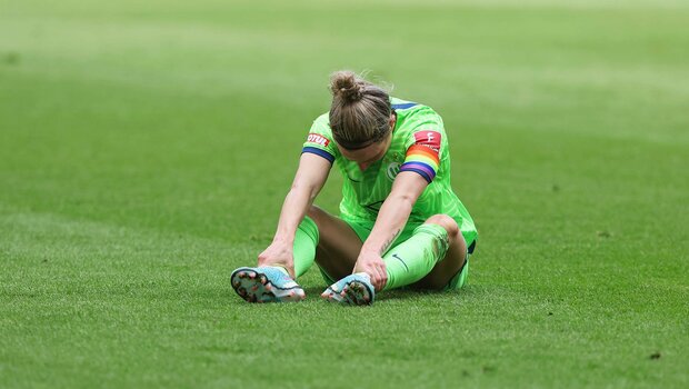 VfL Wolfsburg Kapitänin Svenja Huth sitzt niedergeschlagen auf dem Boden.