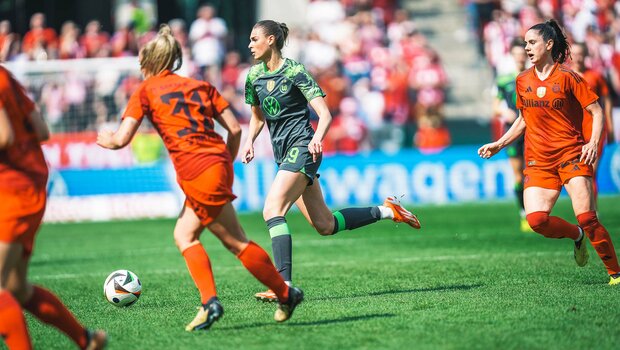 VfL-Wolfsburg-Spielerin Jule Brand läuft mit dem Ball über den Rasen.