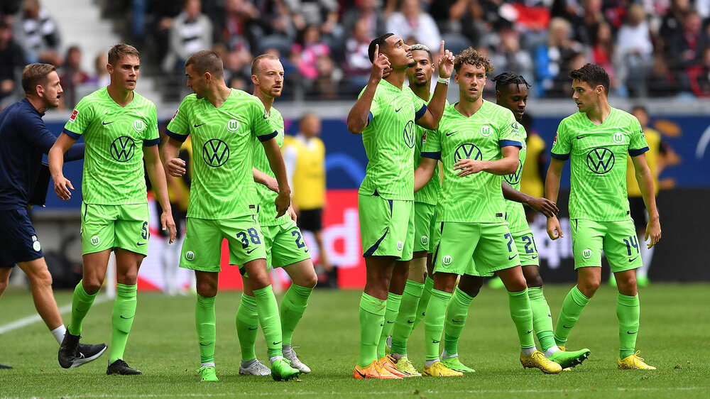 Das Team vom VfL Wolfsburg bejubelt das 1:0 gegen Frankfurt. Lacroix zeigt dankend in den Himmel.