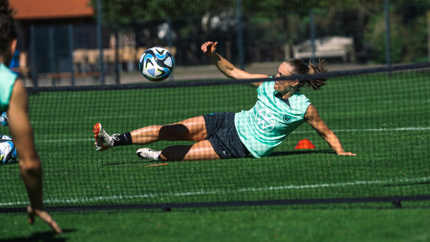 Ewa Pajor vom VfL Wolfsburg nimmt den Ball vom Boden im Liegen an.