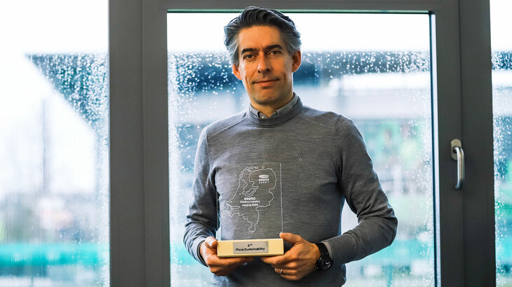 VfL-Wolfsburg-Geschäftsführer Michael Meeske mit dem Award zum Thema Mikroplastik.