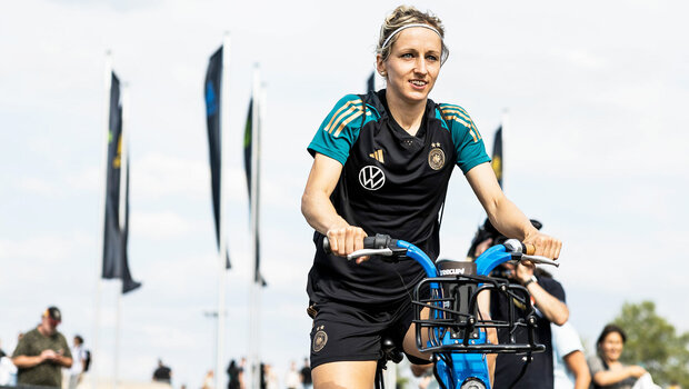 VfL-Wolfsburg-Spielerin Kathy Hendrich fährt auf dem Fahrrad.