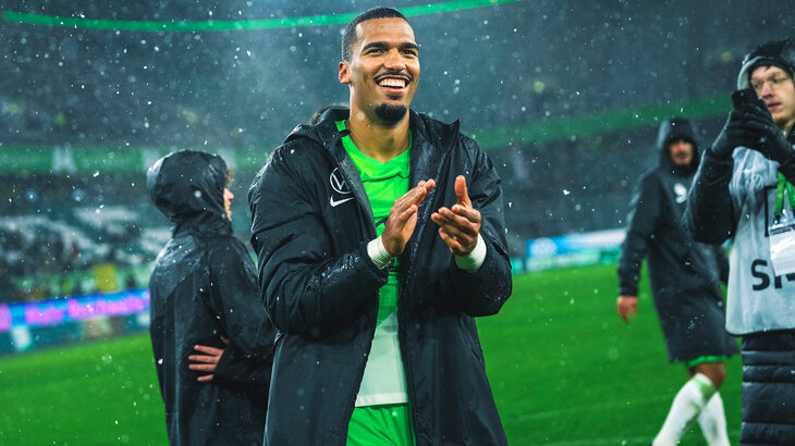VfL-Wolfsburg-Spieler Jenz applaudiert nach dem Spiel den Fans und lächelt.