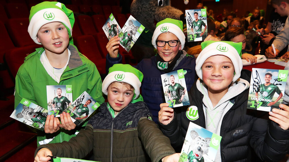 Kinder mit Weihnachtsmützen und Autogrammkarten auf der Kids-Weihnachts des VfL Wolfsburg 2018.