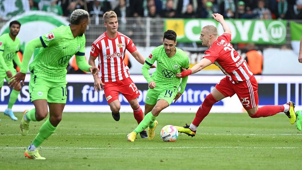 VfL-Wolfsburg-Spieler Josip Brekalo setzt sich gegen einen Gegenspieler durch und läuft hinter dem Ball her.