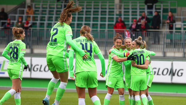 Wils springt jubelnd Roord an, im Hintergrund umarmen sich weitere Wölfinnen im Spiel des VfL Wolfsburg gegen Freiburg.