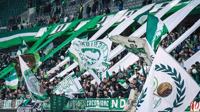 Nach langer Coronapause und 2G-Regeln sind die Ränge der Volkswagen Arena endlich wieder voll. Die Fans jubeln und schwenken ihre Fahnen.