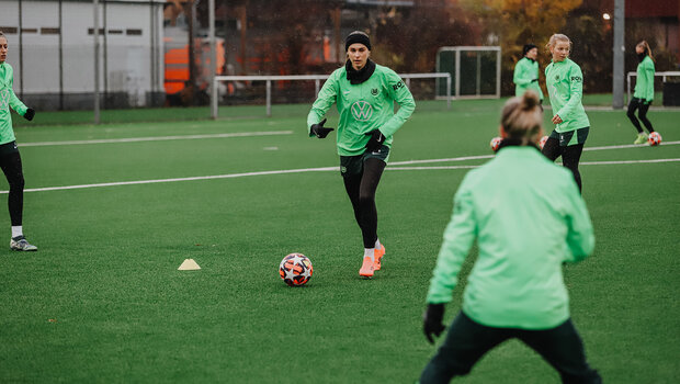 Jule Brand vom VfL-Wolfsburg beim Abschlusstraining vor dem Spiel gegen Galatasaray Istanbul. Sie läuft mit einem Ball am Fuß auf eine andere Spielerin zu. Diese ist von hinten zu sehen.
