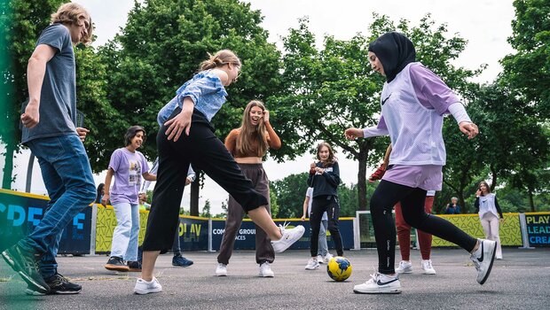 Kinder spielen Fußball in der Schule für Vielfalt.