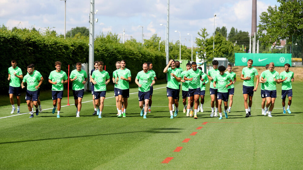 Die VfL Wolfsburg-Spieler laufen sich auf dem Trainingsplatz ein.