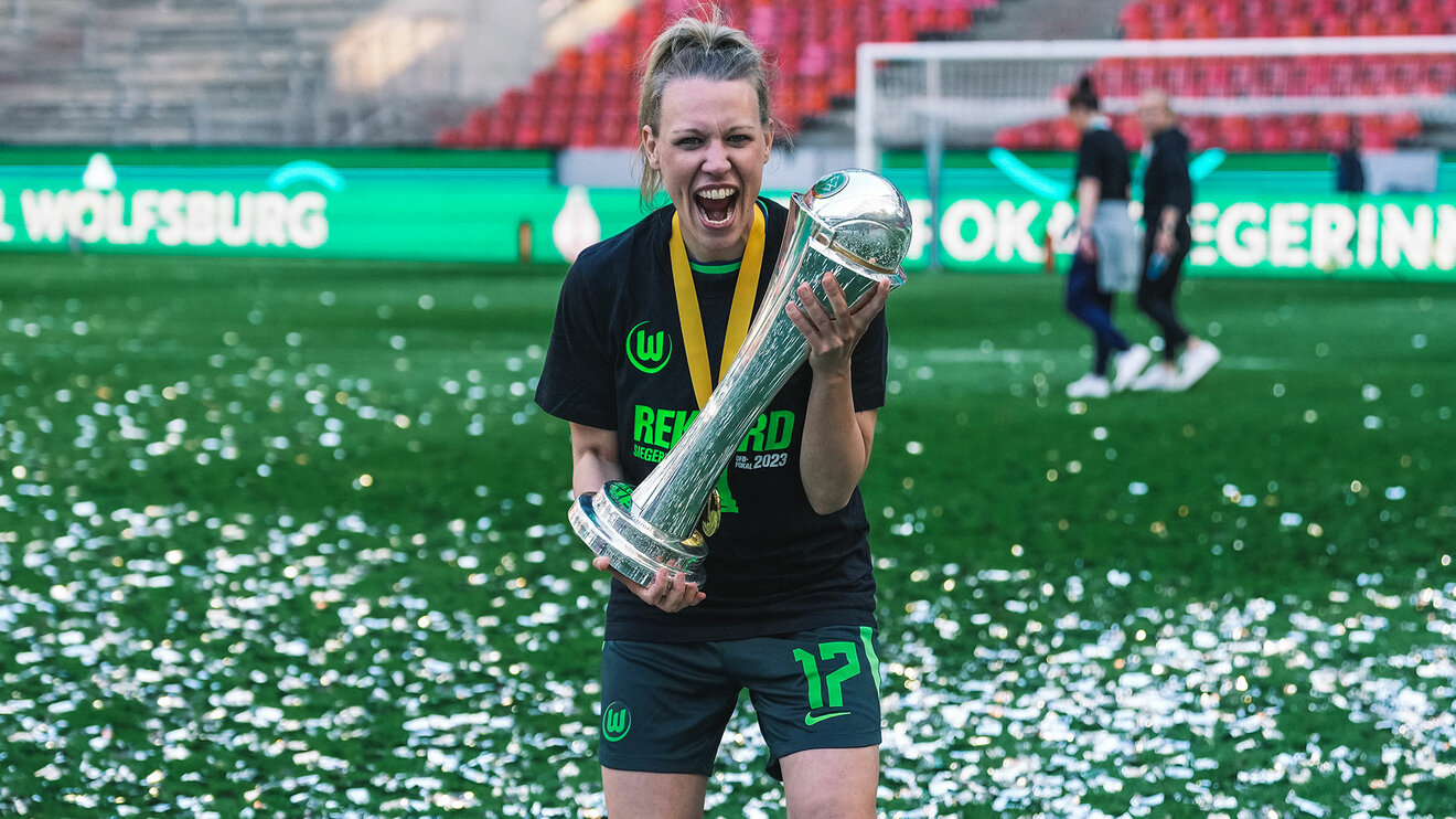 VfL-Wolfsburg-Spielerin Kristian Demann hält den DFB-Pokal und jubelt.
