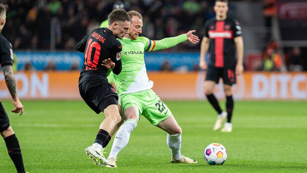 VfL Wolfsburgs Kapitän Maximilian Arnold stellt sich dem Gegner in die Quere und verteidigt so den Ball.