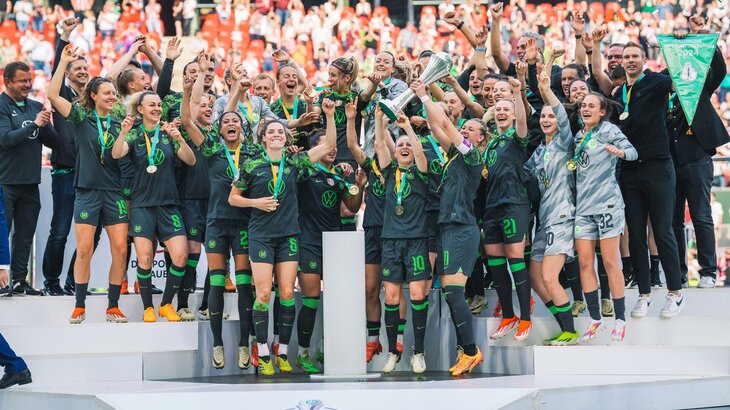 Die VfL-Wolfsburg-Frauen jubeln bei der Pokalübergabe in Köln kollektiv.
