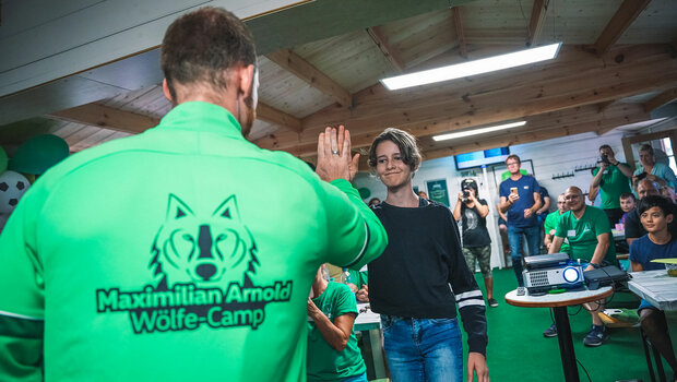 Ein Mädchen klatscht bei VfL Wolfsburg Spieler Maximilian Arnold auf dem nach ihm benannten Wölfe-Club ab.