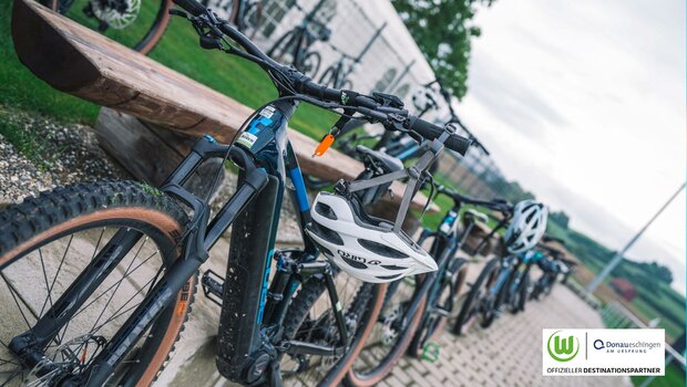 Fahrräder mit Helmen stehen hintereinander.