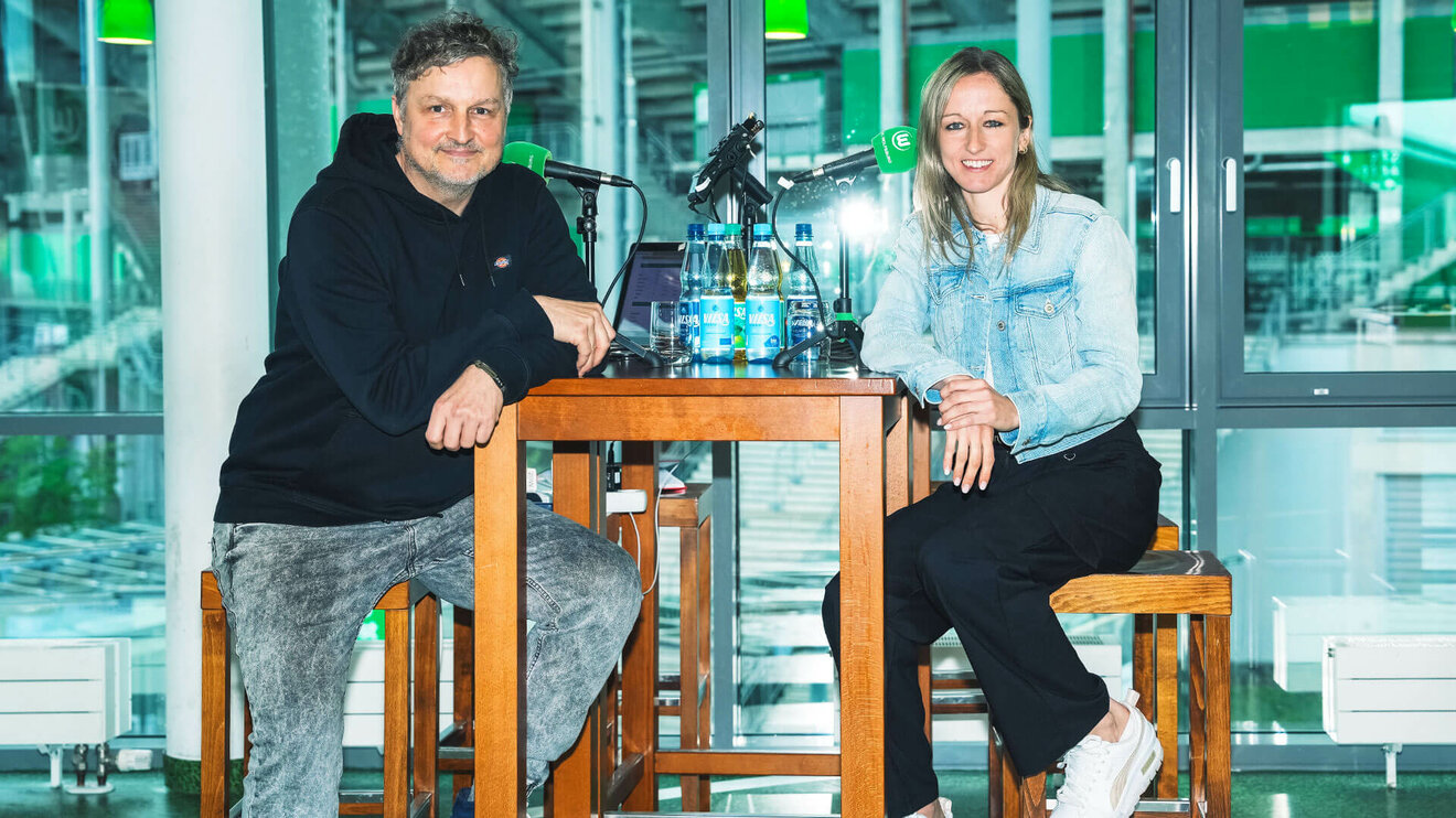 Die VfL-Wolfsburg-Spielerin Kathy Hendrich sitzt bei einer Podcastaufnahme an einem Tisch.