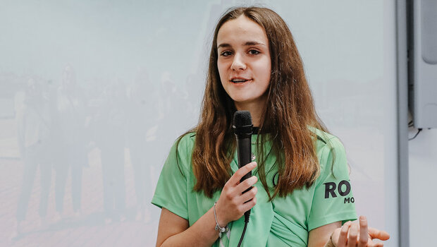 Nelly Smolarcyk spricht mit Miko in der Hand im Grün-Weißen Klassenzimmer.