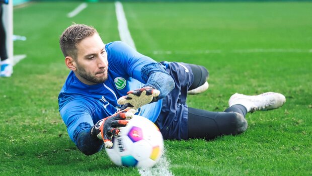 Niklas Klinger vom VfL Wolfsburg fällt zu seiner rechten Seite und wehrt den Ball ab.