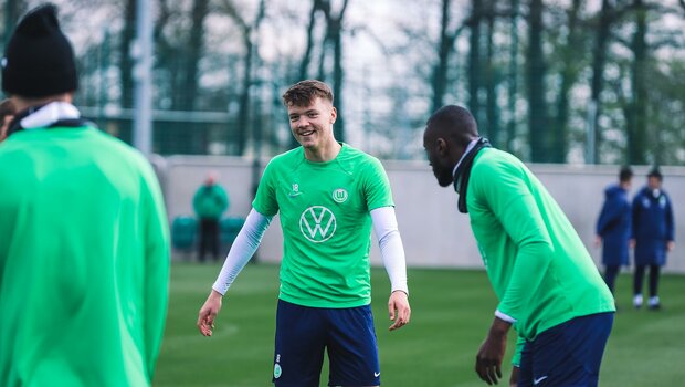 er VfL-Wolfsburg-Spieler Dzenan Pejcinovic lacht mit seinen Teamkollegen im Training.