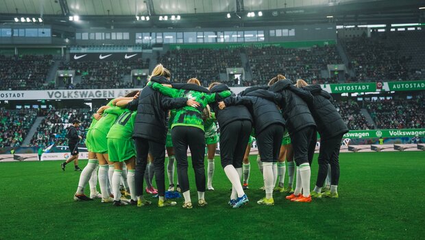 Die Spielerinnen des VfL Wolfsburg bilden ein Spielerinnenkreis.