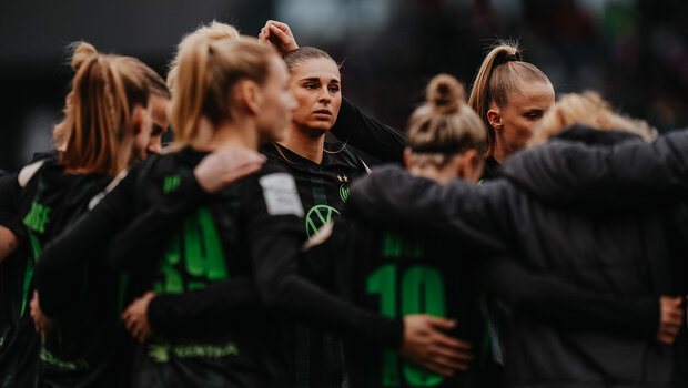VfL-Wolfsburg-Spielerin Jule Brand steht im Kreis zwischen ihren Mitspielerinnen.