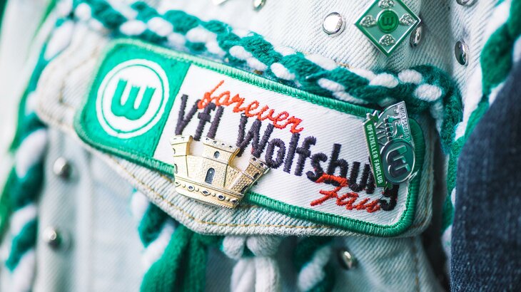 Nahaufnahme eines Aufnähers auf der Brust einer Kutte eines Fans des VfL Wolfsburg.