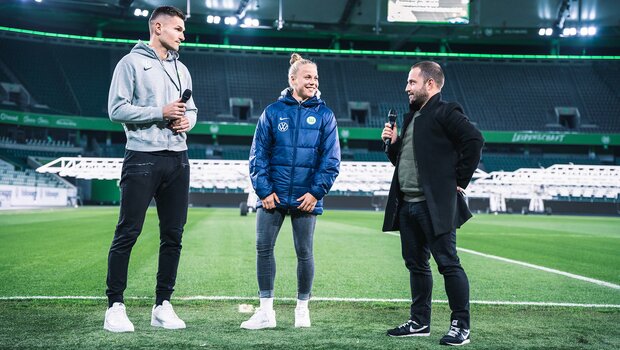 VfL-Wolfsburg-Spieler Pervan und Spielerin Wolter stehen zum Interview auf dem Rasen der Volkswagen Arena.
