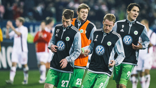 Historisches Foto von VfL Wolfsburg Spielern, die sich vor einem Spiel gegen Augsburg auf dem Platz warmlaufen.