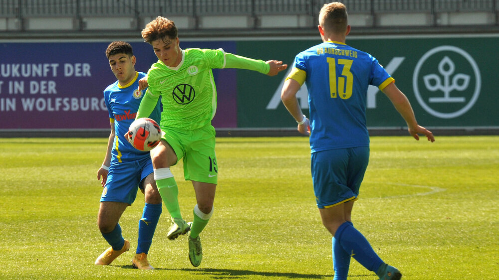 Ein Spieler der U17-Mannschaft des VfL Wolfsburg setzt sich im Zweikampf gegen einen Gegenspieler durch.