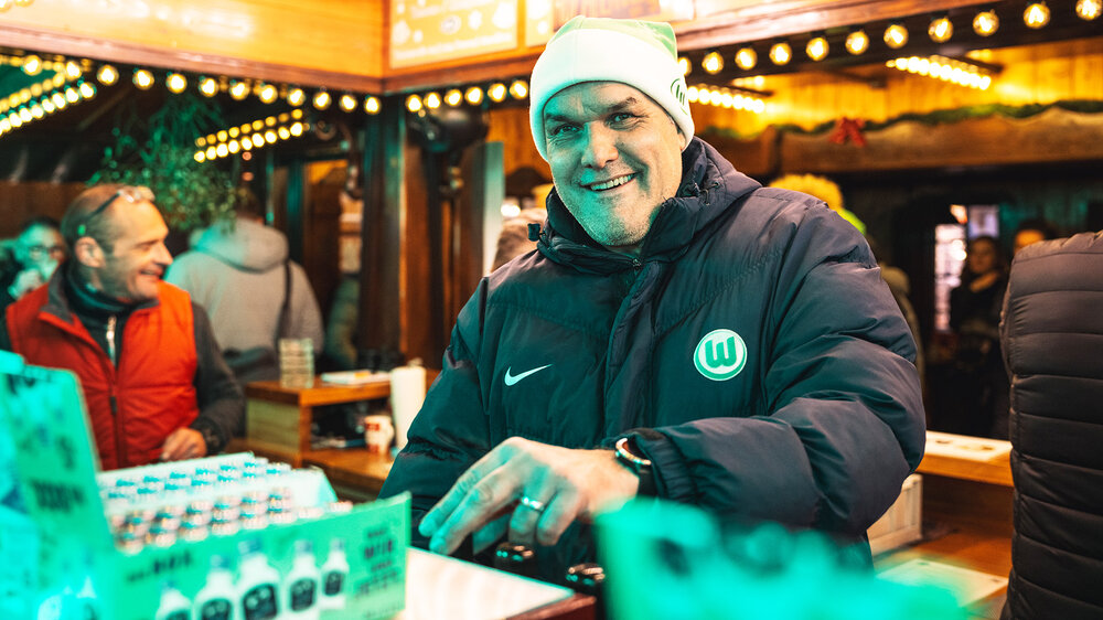 Holger Ballwanz vom VfL Wolfsburg steht in einer Hütte auf dem Weihnachtsmarkt.