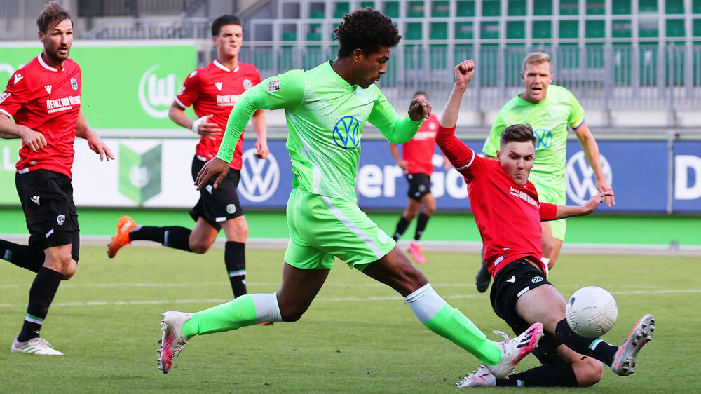 Ein Spieler der U19 Mannschaft des VfL Wolfsburg im Zweikampf mit einem Gegenspieler aus Hannover, der ihm den Ball im Lauf wegschießt.