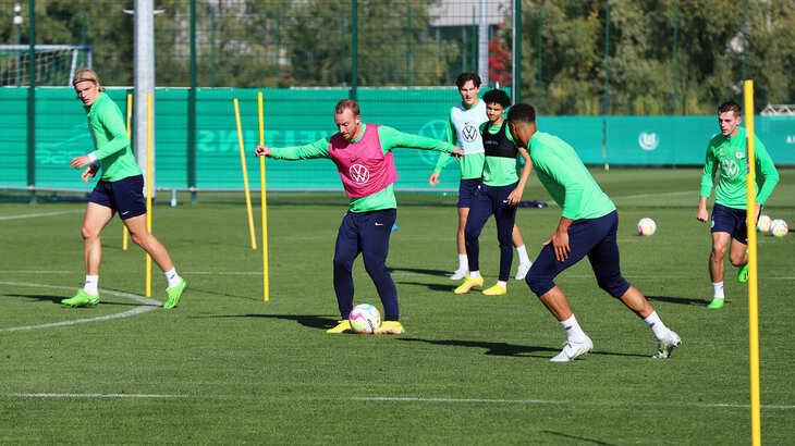 Die Spieler des VfL-Wolfsburg trainieren zusammen. Maximilian Arnold dribbelt mit dem Ball.
