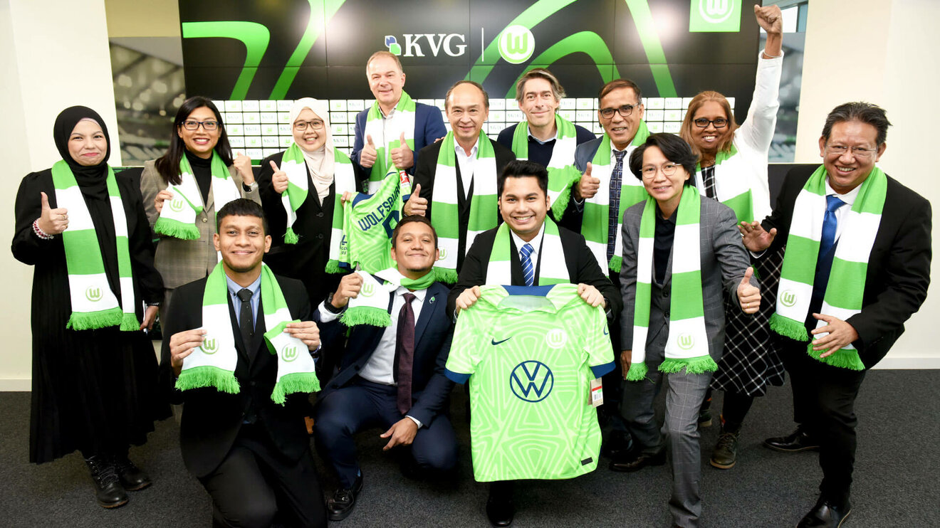 VfL Wolfsburg Funktionäre posieren mit dem neuen Partner des VfL Wolfsburg, KVG.