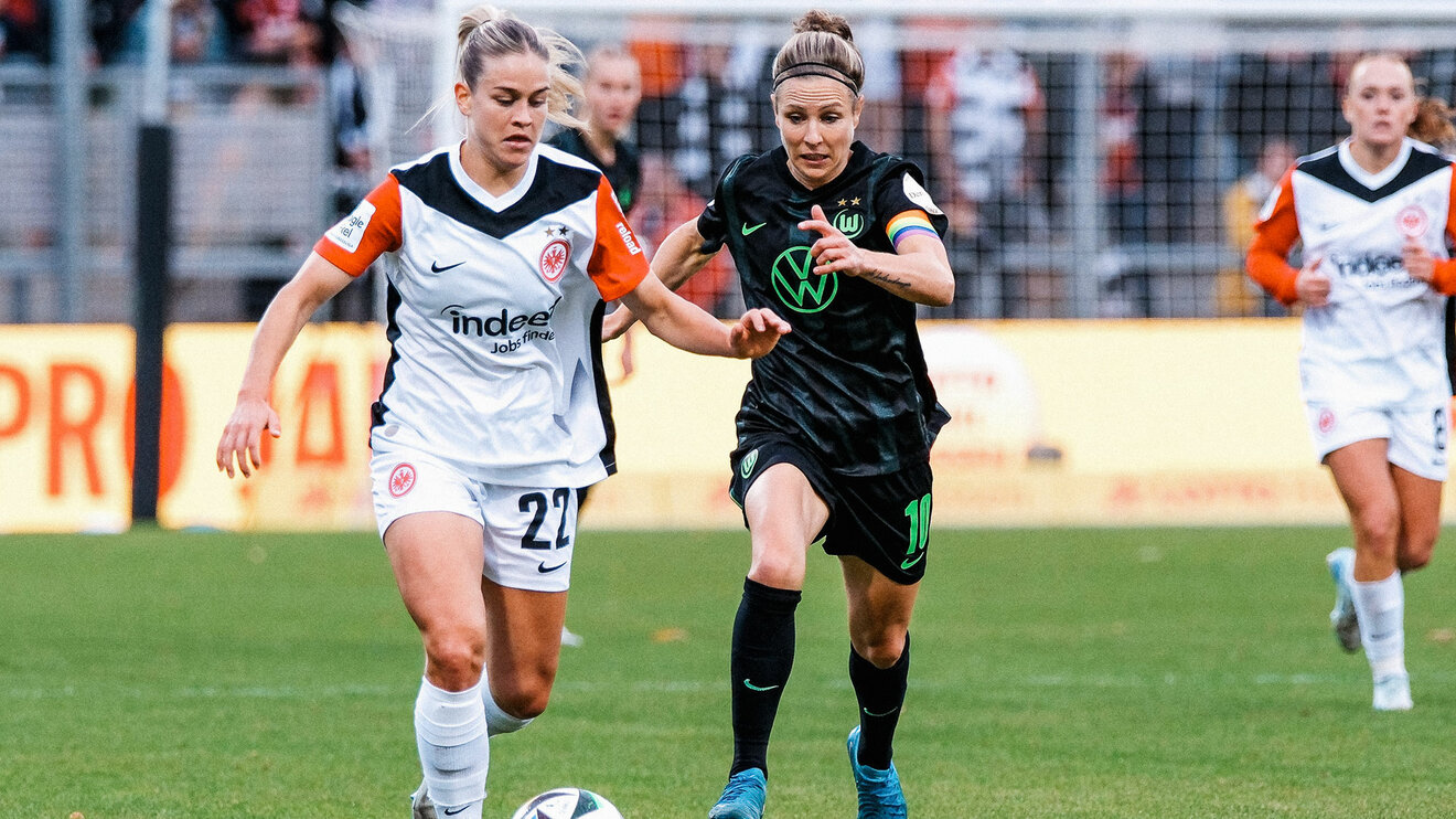 VfL-Wolfsburg-Spielerin Svenja Huth im Zweikampf um den Ball mit einer Gegenspielerin von Eintracht Frankfurt.