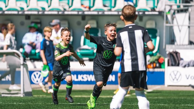 Die Jungen freuen sich über ein gefallenes Tor beim Grundschulfestival des VfL Wolfsburg.