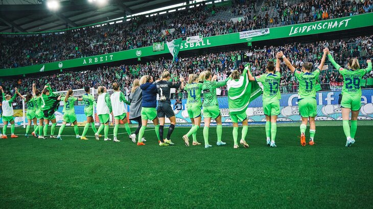 Die Spielerinnen des VfL Wolfsburg jubeln gemeinsam mit den Fans.