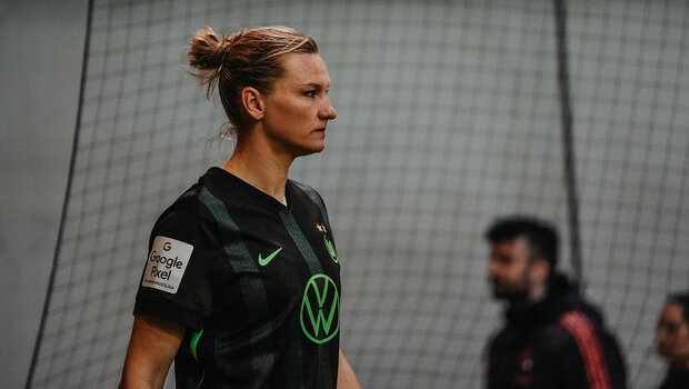 VfL Wolfsburg-Spielerin Popp ist im Profil sichtbar und schaut auf dem Spielfeld in die Ferne.