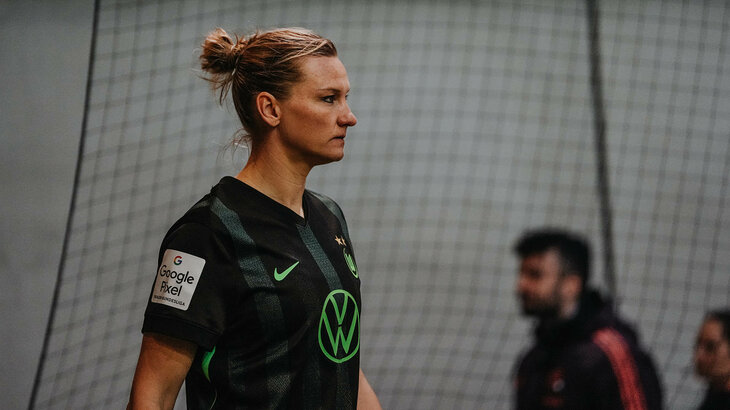 VfL Wolfsburg-Spielerin Popp ist im Profil sichtbar und schaut auf dem Spielfeld in die Ferne.