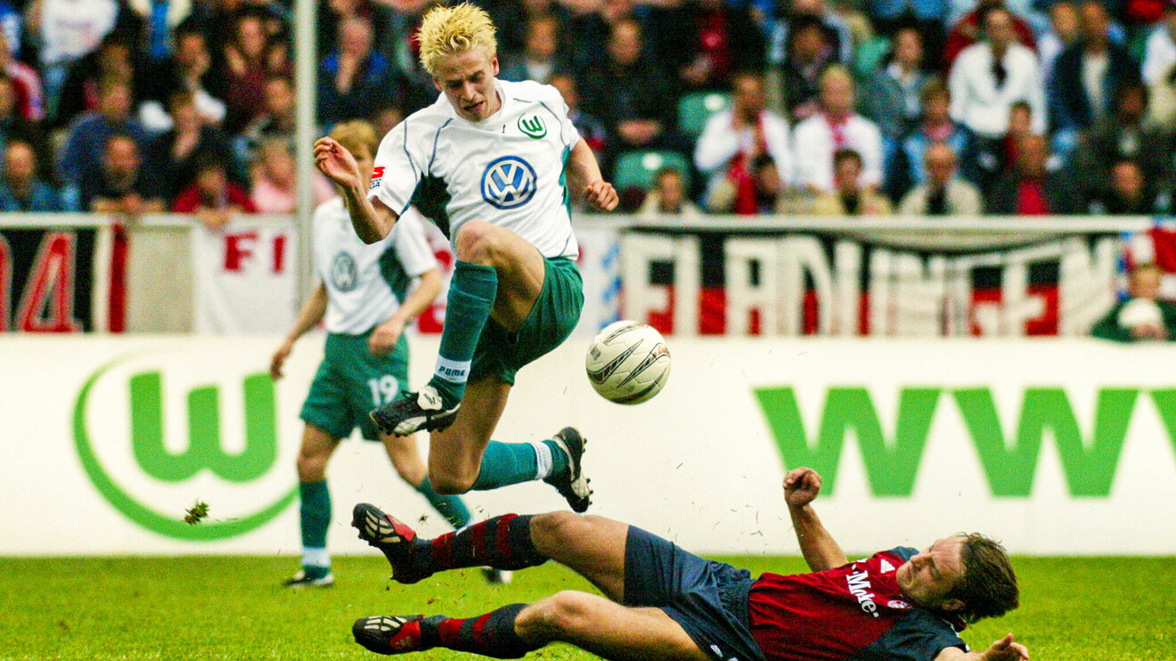 Der ehemalige VfL Wolfsburg-Spieler Tobias Rau springt mit dem Ball über seinen Gegner.