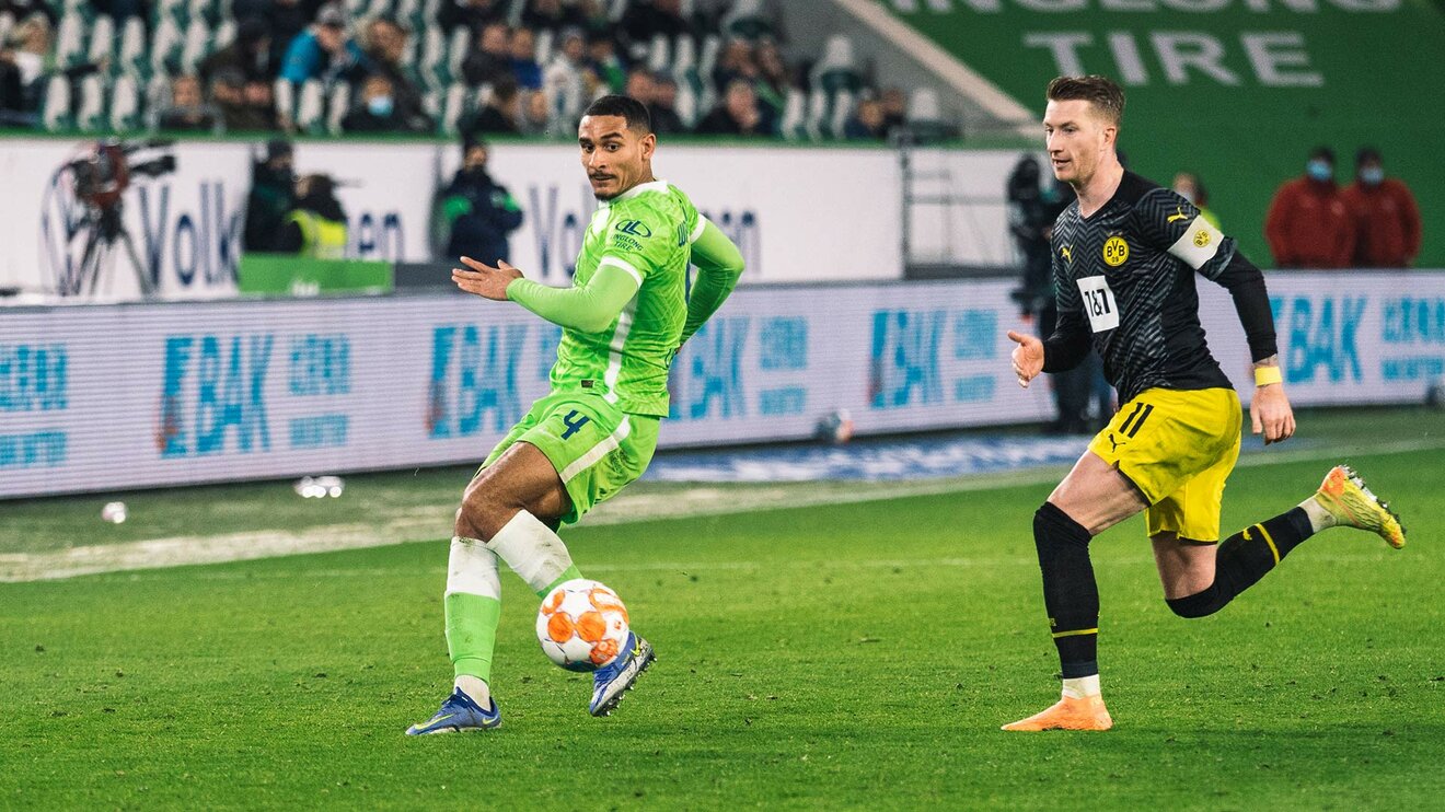 VfL-Wolfsburg-Spieler Maxence Lacroix im Zweikampf mit Marco Reus.