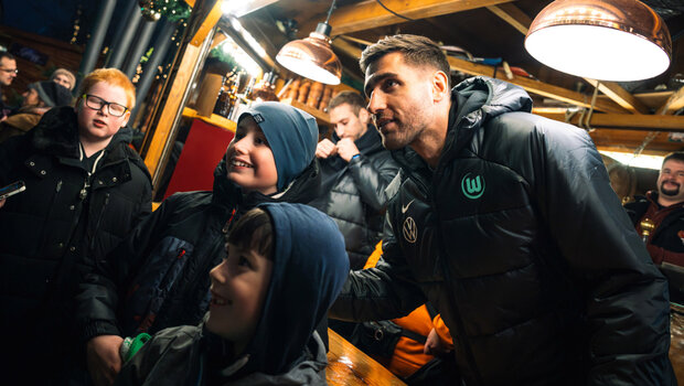 VfL-Wolfsburg-Torhüter Casteels macht Fotos mit kleinen Fans auf dem Weihnachtsmarkt.